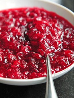 Easy Homemade Cranberry Sauce with spoon in a white bowl