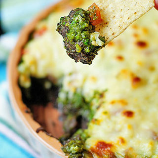 This Warm Layered Black Bean Dip with cilantro pesto and Monterey Jack cheese is a delicious addition to any gathering.