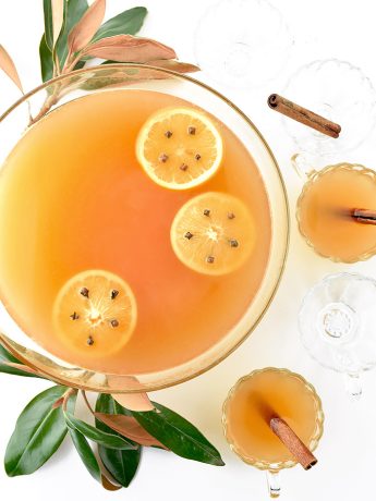 Image of a punch bowl of Wassail. Wassail is a festive spiced punch with apple cider, vodka, oranges, cloves and cinnamon. Wassail is perfect for holiday entertaining.
