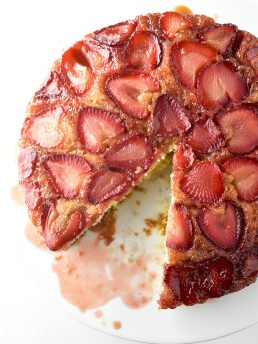 over the top picture of strawberry cake with one slice cut out