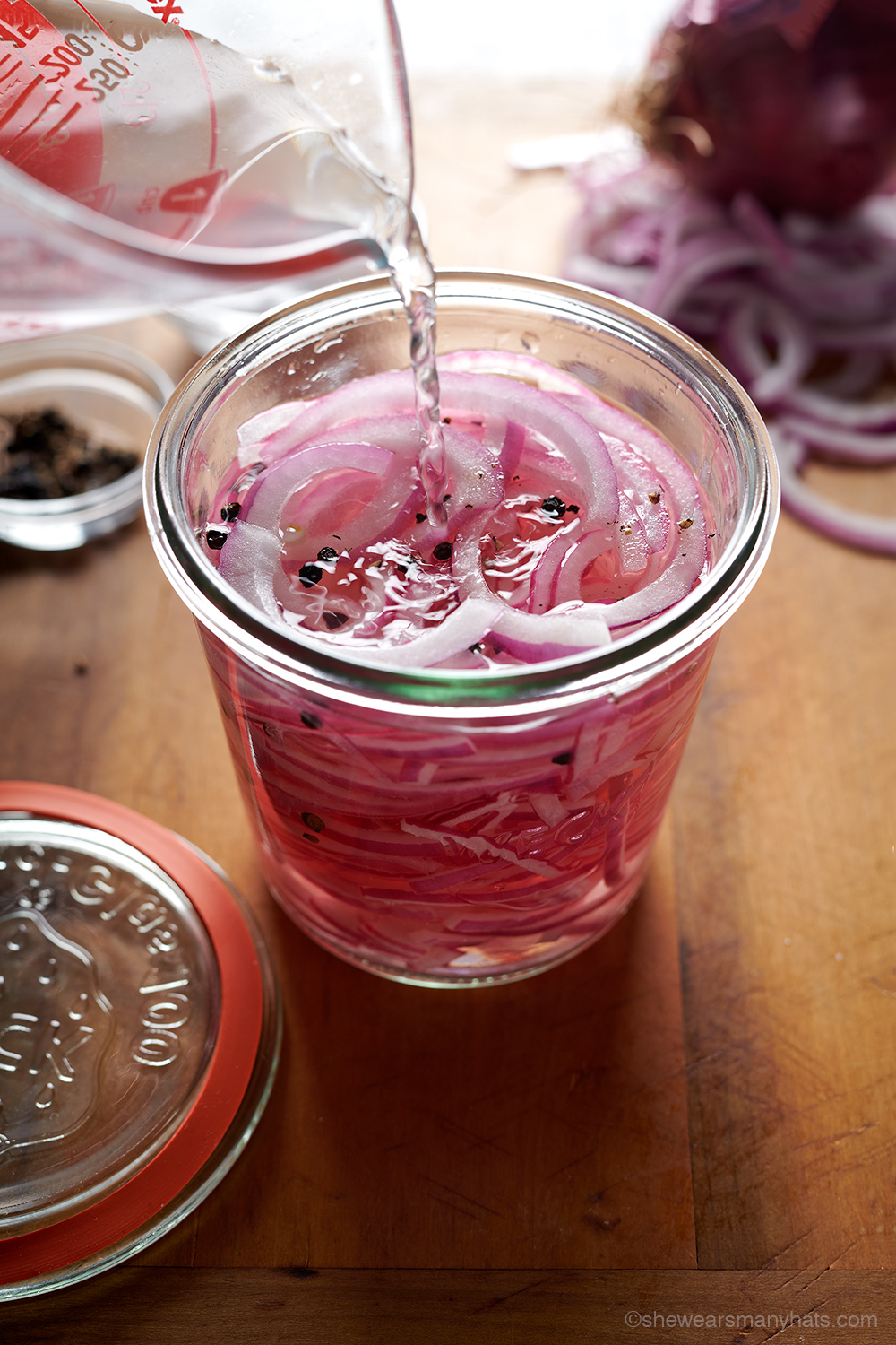 image of vinegar being poured over jar of sliced onions for Pickled Red Onion Recipe